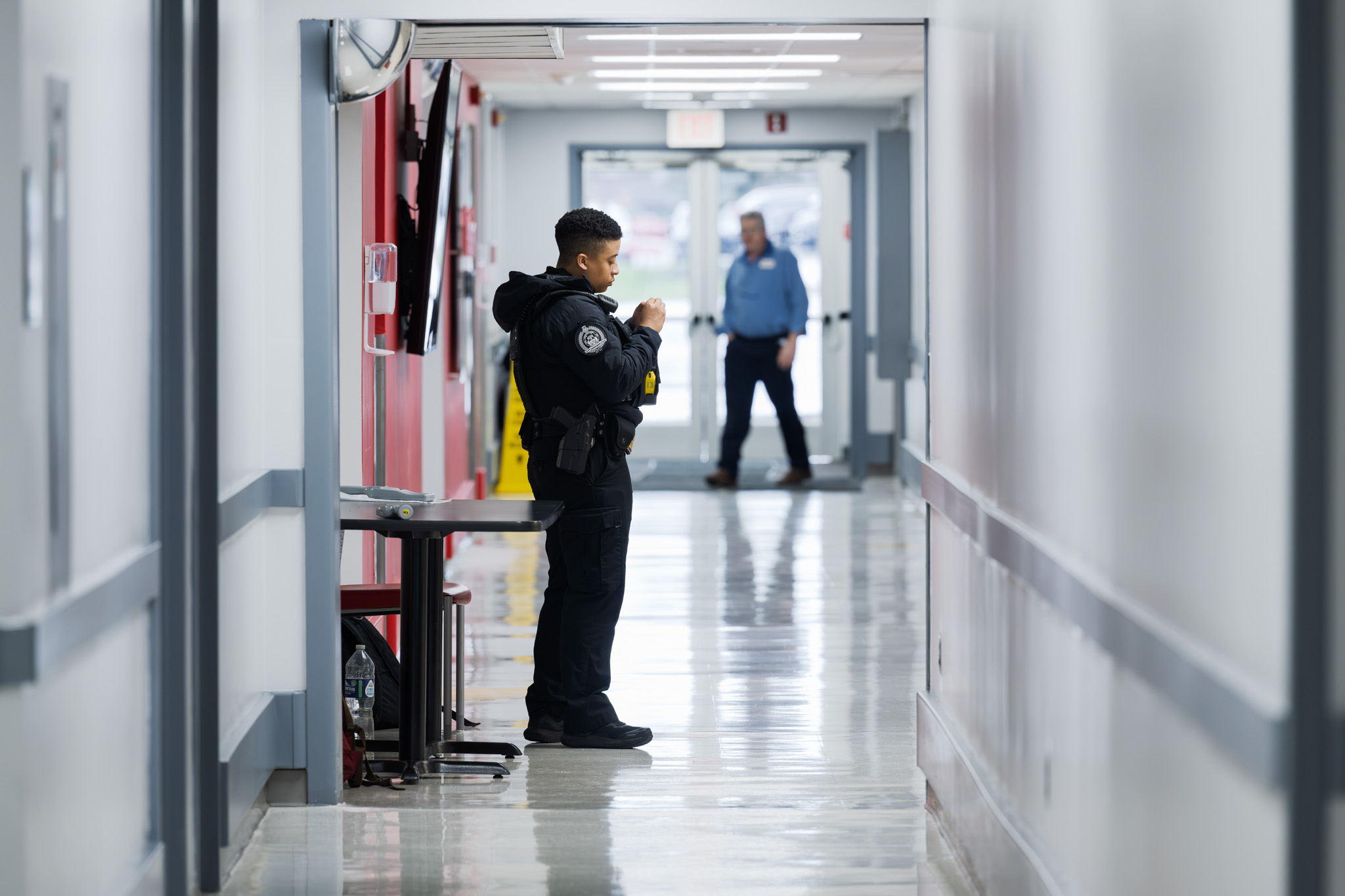 A security officer stands watch in the facility hallway during the visit